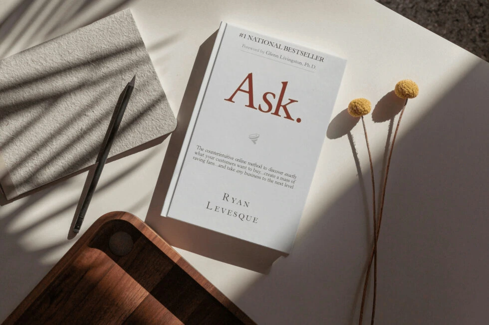 A book titled "platform: get noticed in a noisy world" by michael hyatt, along with a pen, dried flowers, and a wooden surface.